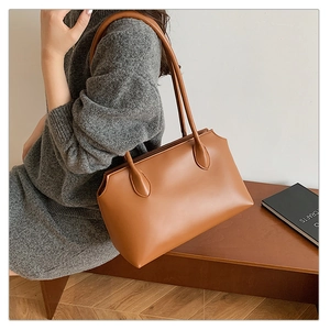 Detailed close-up of brown leather tote bag with wavy top edge on model for daily use