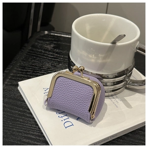 Detailed view of a purple lychee leather coin purse with a vintage gold kiss-lock closure