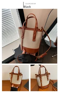 Detail view of canvas bucket bag with brown leather trim and adjustable shoulder strap