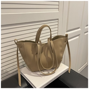 Detail of lychee pattern leather tote bag with dual straps on a minimal background