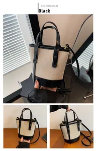 Detailed view of the canvas bucket bag with black leather trim and gold-tone hardware