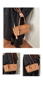 Detail of brown faux suede tote bag with wooden bead tassel and fashion logo tag