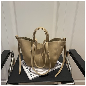 Detailed texture of beige lychee grain leather bucket bag on a minimalist chair