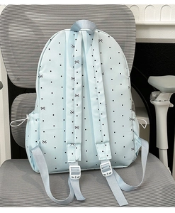 Detail of adjustable straps and drawstring side pocket on light blue polka dot backpack