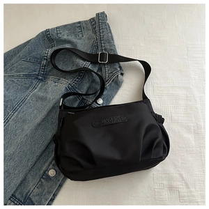 Detail of black nylon crossbody bag with adjustable strap and JINGPIN leather logo patch