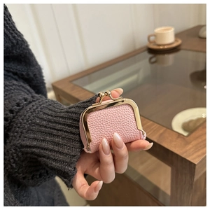 Mini pink pebble leather coin purse with vintage gold clasp held in hand for scale