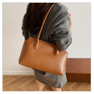 Minimalist caramel brown leather tote bag shown on model for a chic commuting style