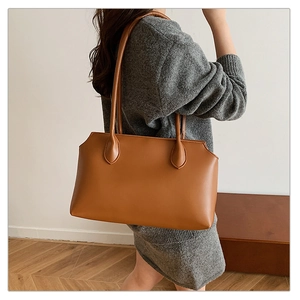 Close-up of caramel leather tote bag with slim shoulder straps and smooth finish
