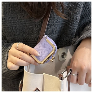 Mini purple litchi texture coin purse with gold frame held as a bag accessory