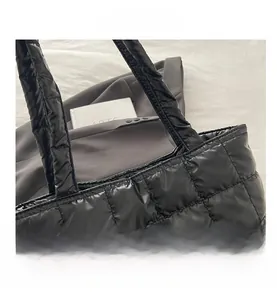 Close-up of black quilted nylon tote bag with glossy finish and rhombus pattern