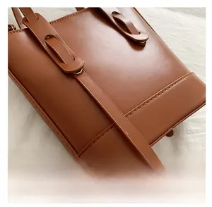 Detail of premium brown PU leather bucket bag with precise stitching and gold hardware
