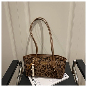 Detail of leopard print tote bag with brown handles and stylish beaded charm