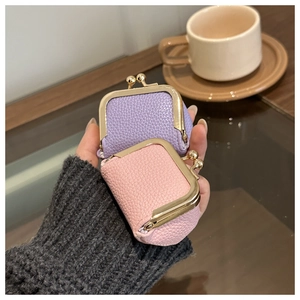 Detailed close-up of mini leather jewelry pouches with textured finish and gold kiss-lock