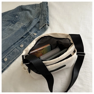 Detail view of large capacity beige crossbody bag with notebooks and daily items inside