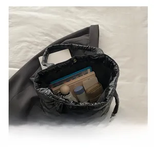 Macro view of a black quilted tote bag interior showing large capacity and daily items