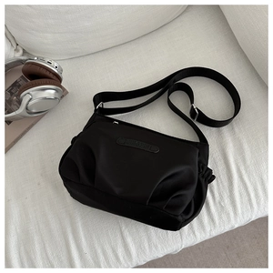 Detail of waterproof nylon crossbody bag with JINGPIN leather label and side drawstring