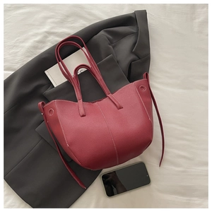 Close-up of wine red lychee grain leather tote bag with white contrast stitching detail