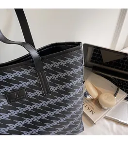 Detail view of large capacity black tote bag with gray wave pattern and office accessories