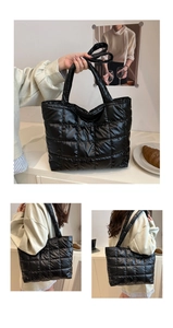 Detail of black quilted puffer tote bag with glossy finish and large grid stitching