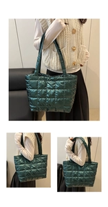 Detail of dark green quilted puffer tote bag with metallic finish and square patterns