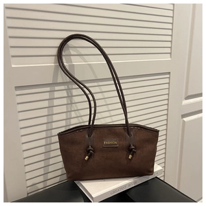 Detail view of coffee brown suede shoulder bag featuring a knotted strap and gold hardware