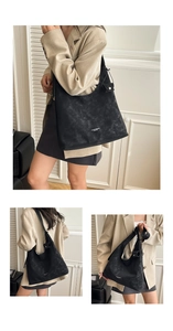Close-up of black suede tote bag with printed logo and detachable mini pouch accessory