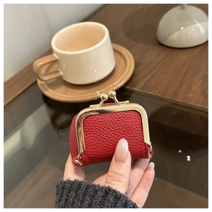 Close-up of a mini red lychee pattern leather coin purse with golden metal clasp