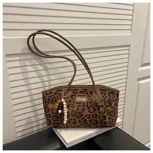 Detail of leopard print suede shoulder bag with beaded fringe tassel and fashion label