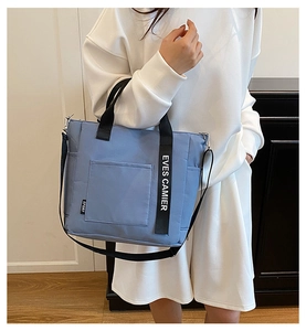 Fog blue canvas lunch tote with SPORT label and EVES CAMIER strap being worn by a model
