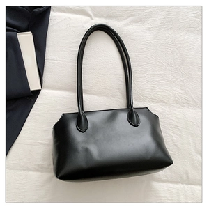 Macro detail of minimalist black tote bag with matte synthetic leather on white fabric