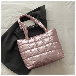 Detail of pink metallic quilted tote bag on black blazer with a wide shoulder strap