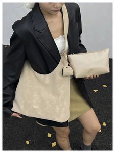Detail of beige faux leather tote bag and matching pouch with textured finish