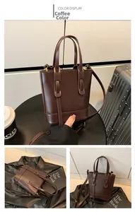 Detail view of dark coffee bucket bag featuring decorative straps and matte leather finish