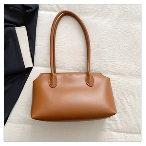 Detailed view of a vintage brown tote bag with smooth texture on a white textured background