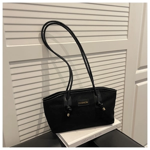 Close-up of black velvet tote bag with golden fashion logo and metallic strap details