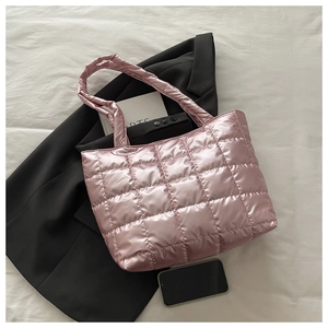 Detail of pink metallic quilted tote bag with padded texture on a black blazer