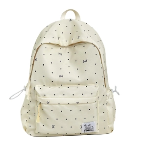 Minimalist beige backpack with black polka dots and bows featuring durable canvas material