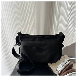 Detail view of black oxford nylon crossbody bag with multiple zippers and adjustable strap