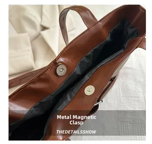 Detail of premium brown leather tote bag showing high-quality magnetic closure and stitching