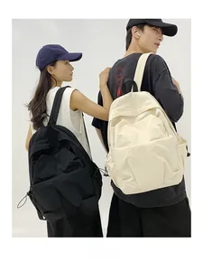 Detail of large nylon backpacks in black and beige showing side drawstring features