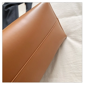 Detail view of the brown leather tote bag showing high-quality bottom stitching