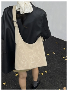 Close-up of beige marble pattern tote bag featuring adjustable strap and logo detail