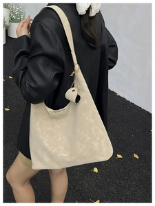 Detail of off-white matte leather tote bag with wide strap and fashion lettering