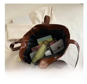 Top view of spacious brown tote bag interior showing umbrella, wallet, and phone storage