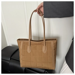 Detail of khaki quilted tote bag with square stitching and long leather handles