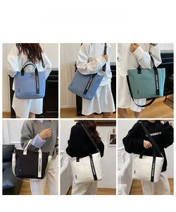 Détail de grands sacs fourre-tout en Oxford imperméable en plusieurs couleurs assorties