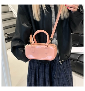 Close-up of pink glossy PVC jelly bag showing round handles and metallic hardware details