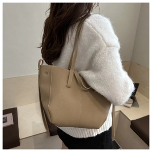 Détail du sac cabas en cuir kaki avec surpiqûres blanches et texture grainée élégante