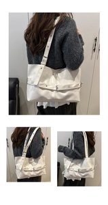 Detail of white PU leather tote bag with decorative belt buckle and adjustable strap