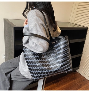 Detail of large tote bag with blue and grey zigzag pattern and black leather straps